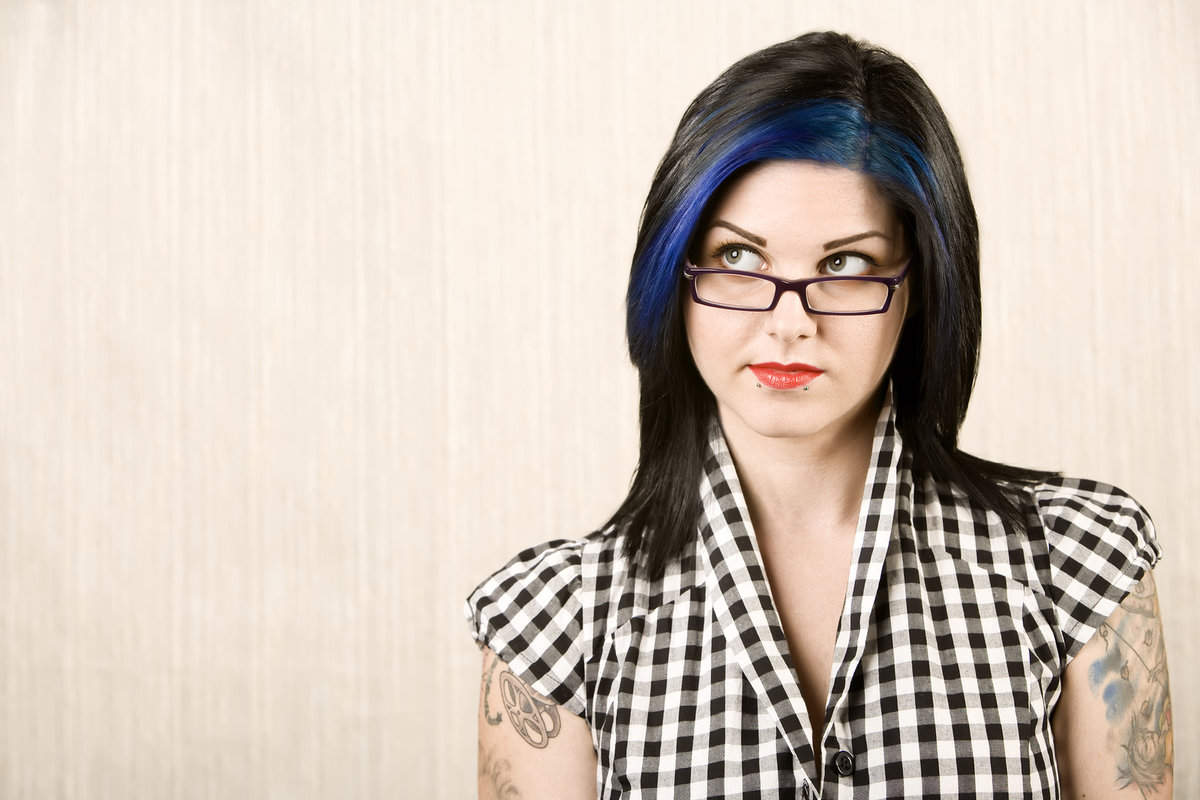 Woman with tattoos staring to the right as if in thought