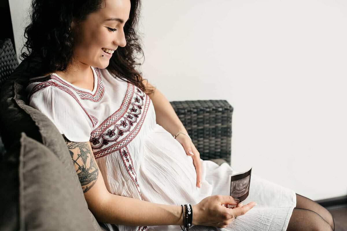 Pregnant woman touching her belly thinking about getting laser tattoo removal